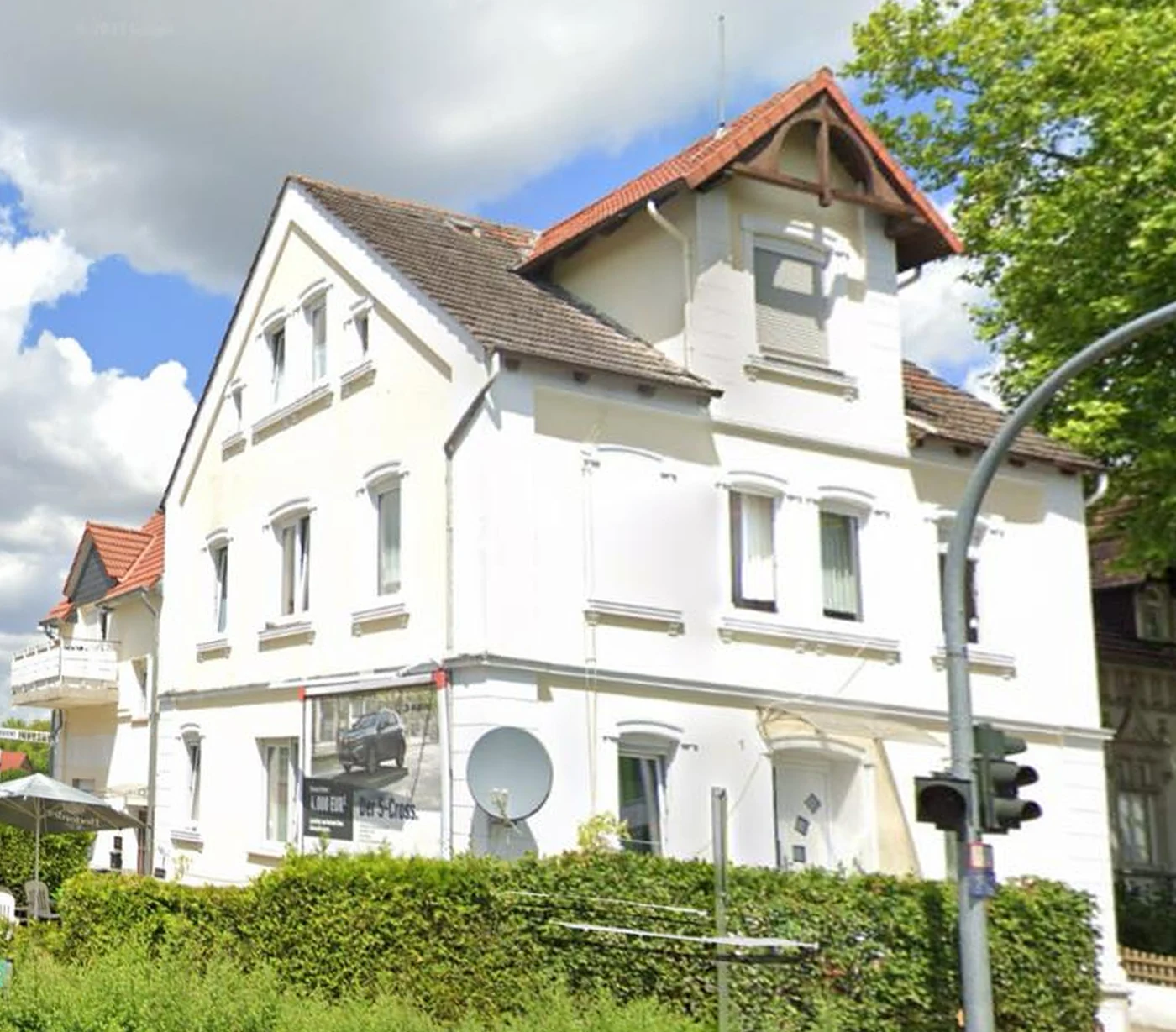 Vorher: weiß verputzte Fassade mit roten Dachziegeln, ausgeblichen und verschmutzt